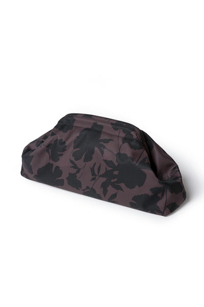 A dark brown and black floral patterned clutch bag, photographed from an angle on a clean white background.