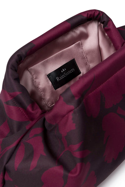 Women's burgundy floral clutch bag featuring a rich wine-toned floral print, structured silhouette, secure frame closure, and elegant ashy pink lining.