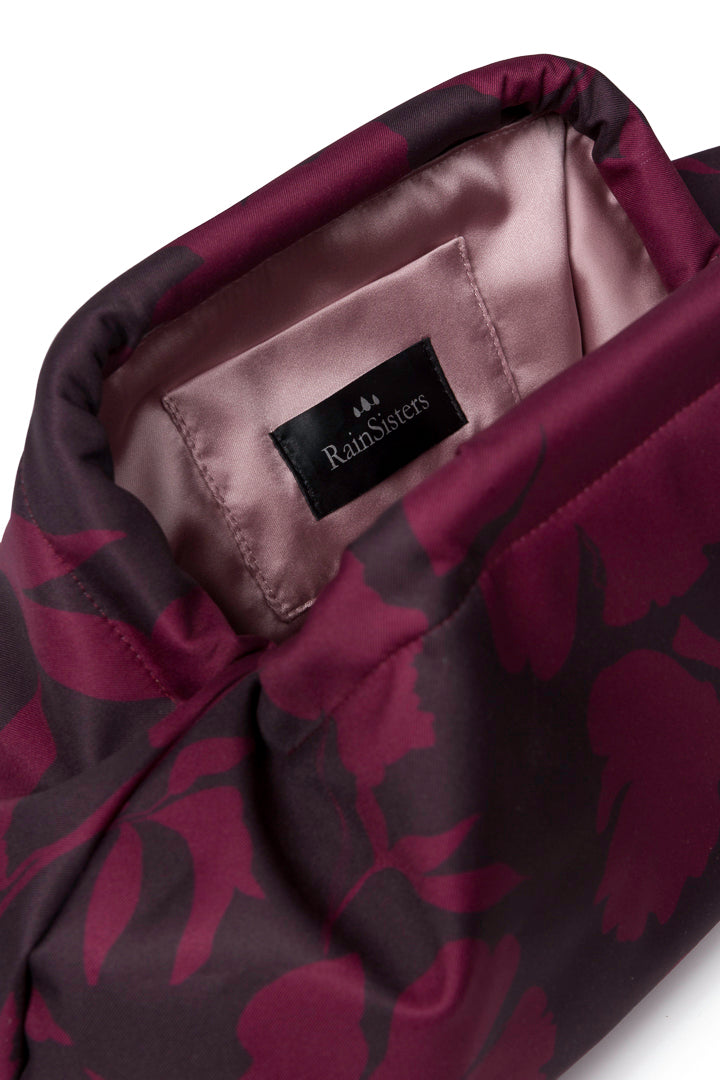 Women's burgundy floral clutch bag featuring a rich wine-toned floral print, structured silhouette, secure frame closure, and elegant ashy pink lining.