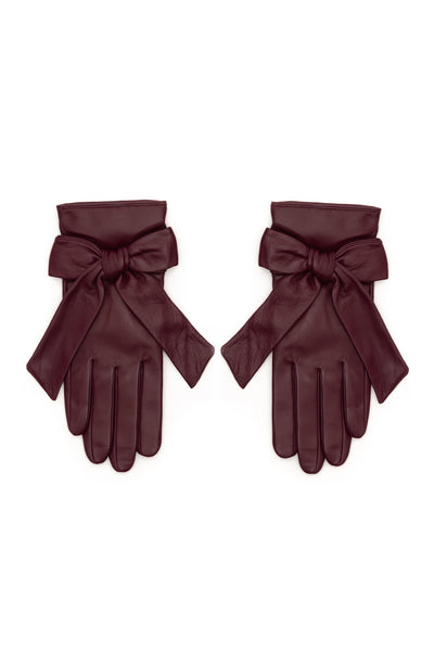 A pair of burgundy leather gloves with wide wristbands and large bow details, displayed flat against a plain white background.
