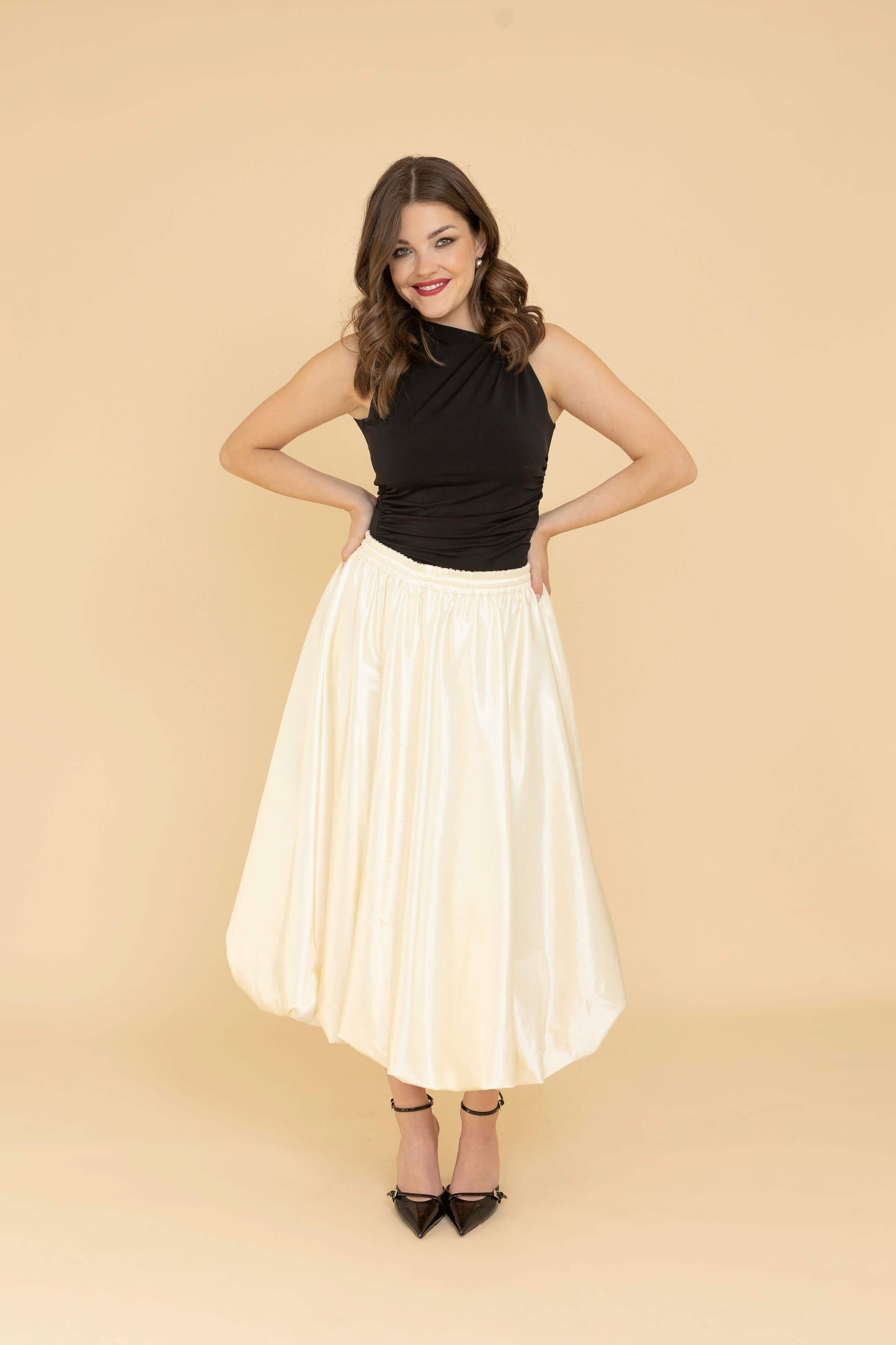 Off-white balloon midi skirt with hidden pockets, 80 cm length, and adjustable drawstring waist, perfect for styling with coats or festive dresses.