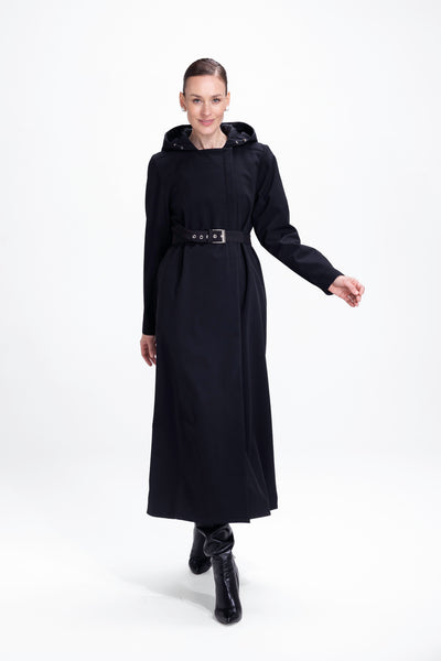Model in motion wearing elegant black trapeze coat with timeless tailored silhouette