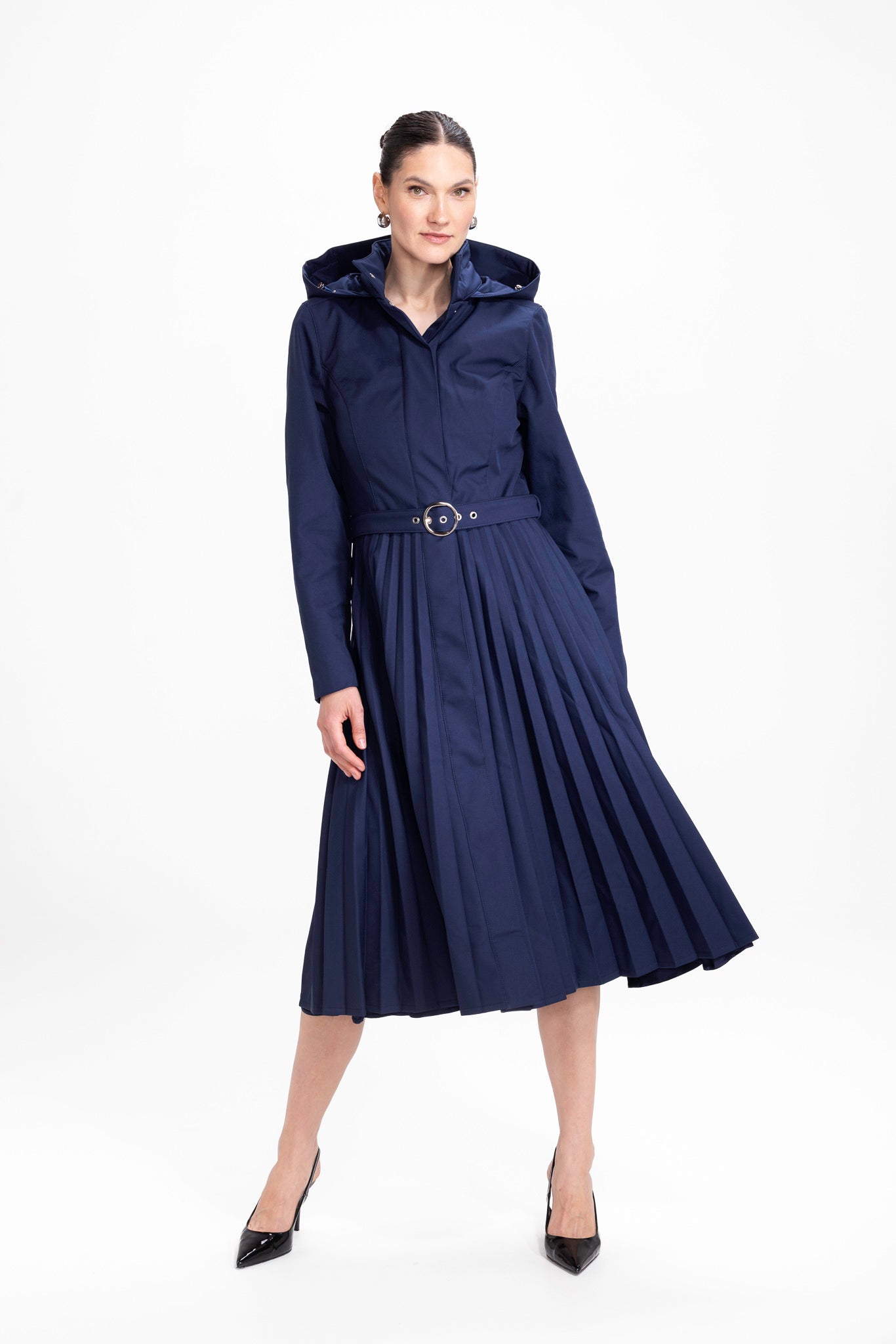 Model in motion wearing elegant navy blue fit-and-flare women's trench coat with flowing pleated skirt