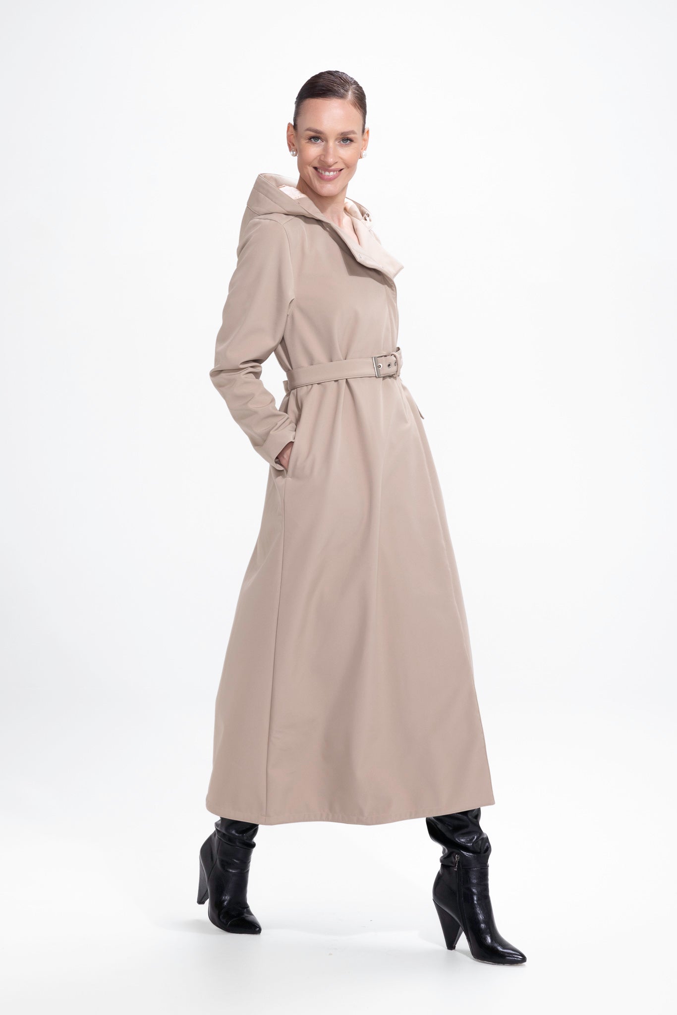 Model in motion wearing elegant beige trench coat with timeless trapeze silhouette