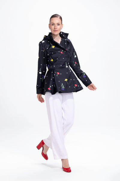 Model in motion wearing black floral water-resistant jacket with feminine tailored silhouette
