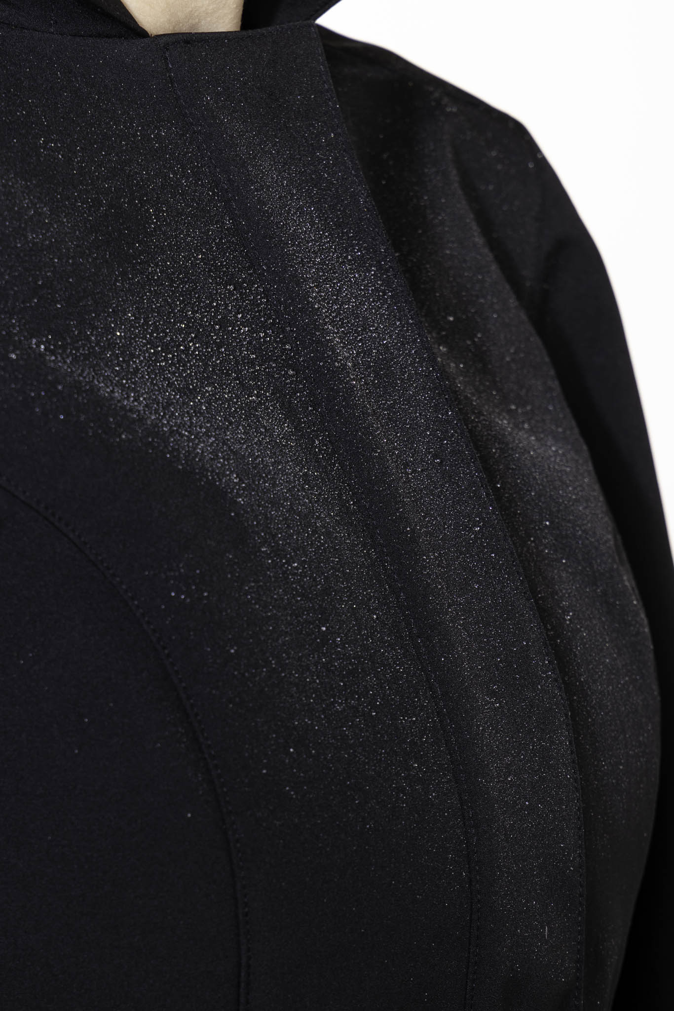 Black tailored outerwear fabric with emerald green satin lining contrast detail on women's coat