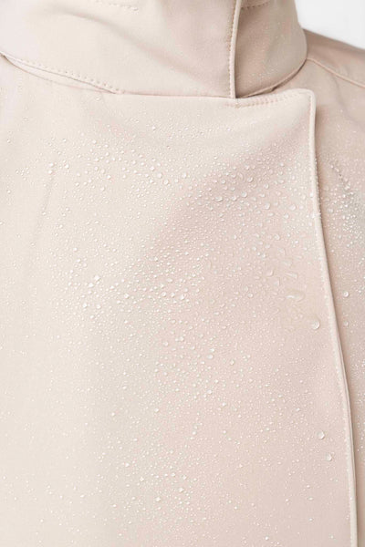 Close-up of beige waterproof outerwear fabric on women's designer trench coat