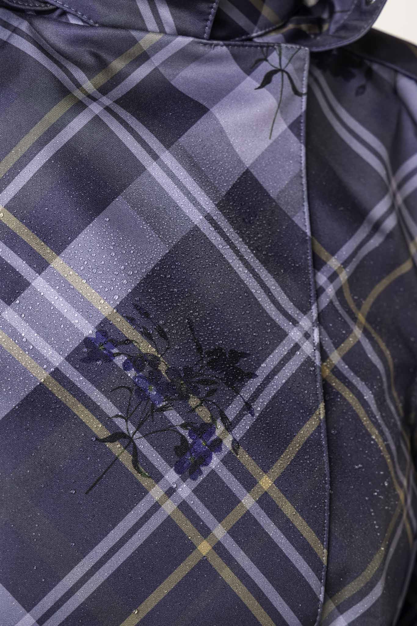 Greyish-blue plaid fabric with delicate blue floral details on women's designer trench coat