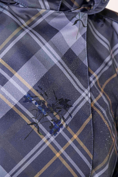 Greyish-blue plaid fabric with delicate blue floral details on women's designer trench coat