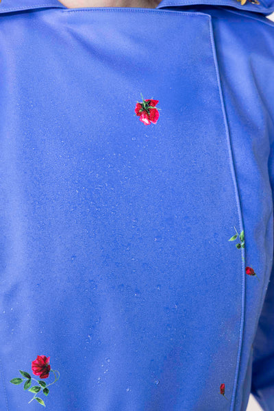 Water droplets on blue waterproof trench coat fabric showing protective outerwear performance