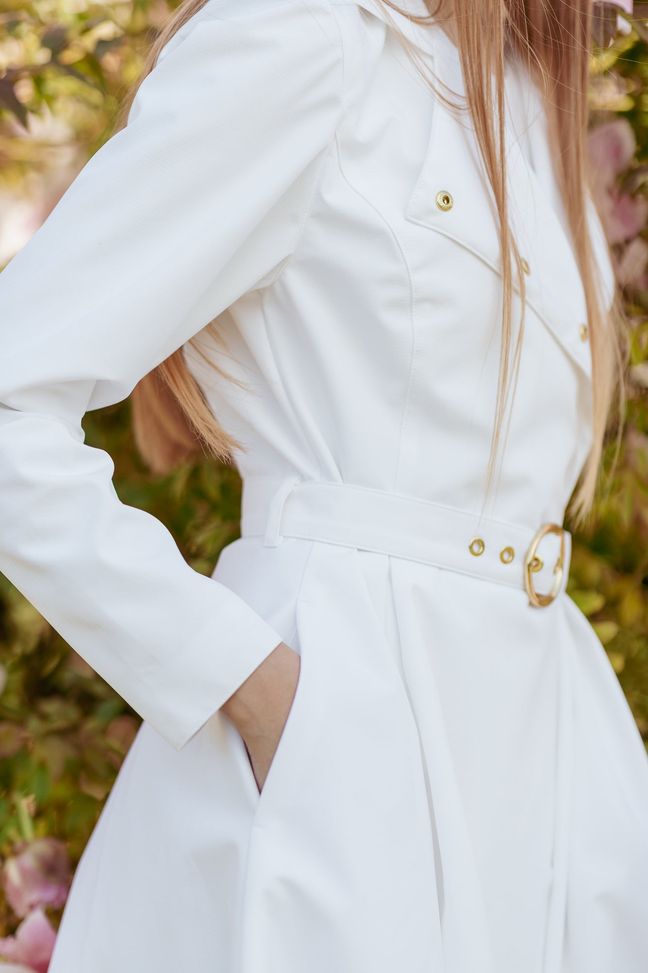 Woman wearing elegant white trench coat styled as modern bridal and wedding outerwear