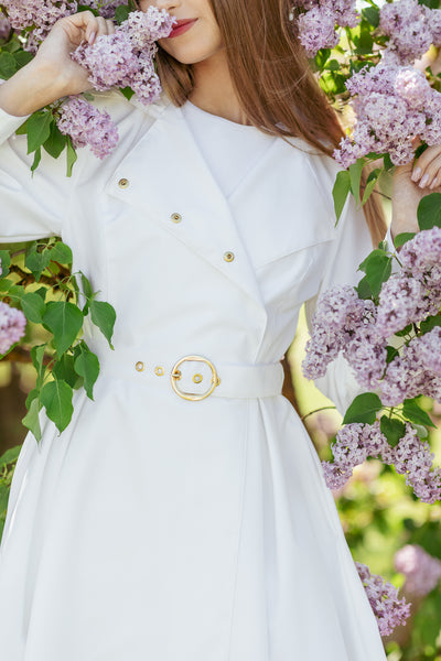 Gold-tone hardware belt detail on white bridal-inspired women's coat