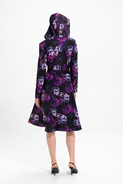 Back view of black water-resistant women's coat with vibrant purple floral print and fitted waist