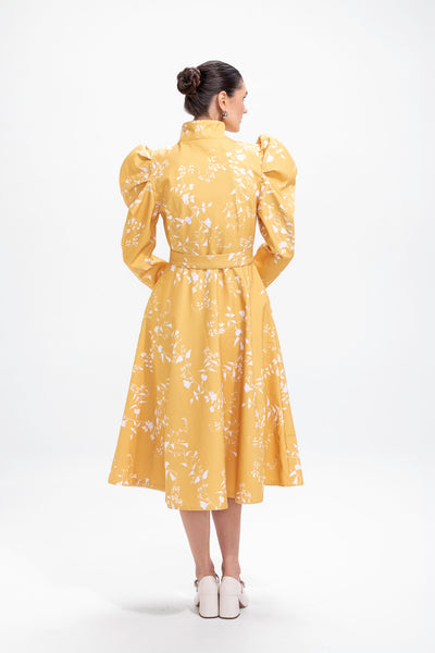 Back view of bright yellow women's coat with white floral print and flared silhouette