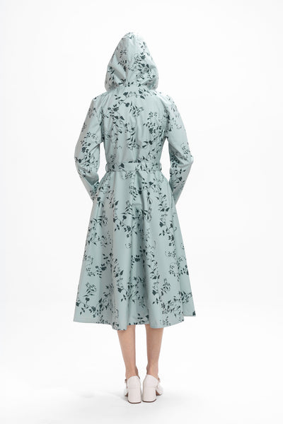 Back view of mint green women's trench coat with dark green floral pattern and tailored fit