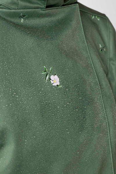 Water droplets on green water-resistant coat fabric showing breathable protection and performance outerwear