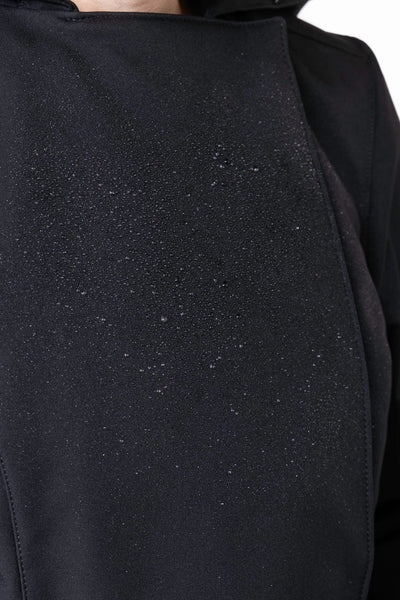 Close-up of solid black tailored waterproof outerwear fabric on women's designer trench coat
