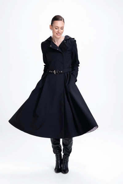 Model in motion wearing elegant black women's trench coat with timeless tailored silhouette
