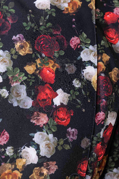 Close-up of red rose print on black fashion raincoat fabric by RainSisters