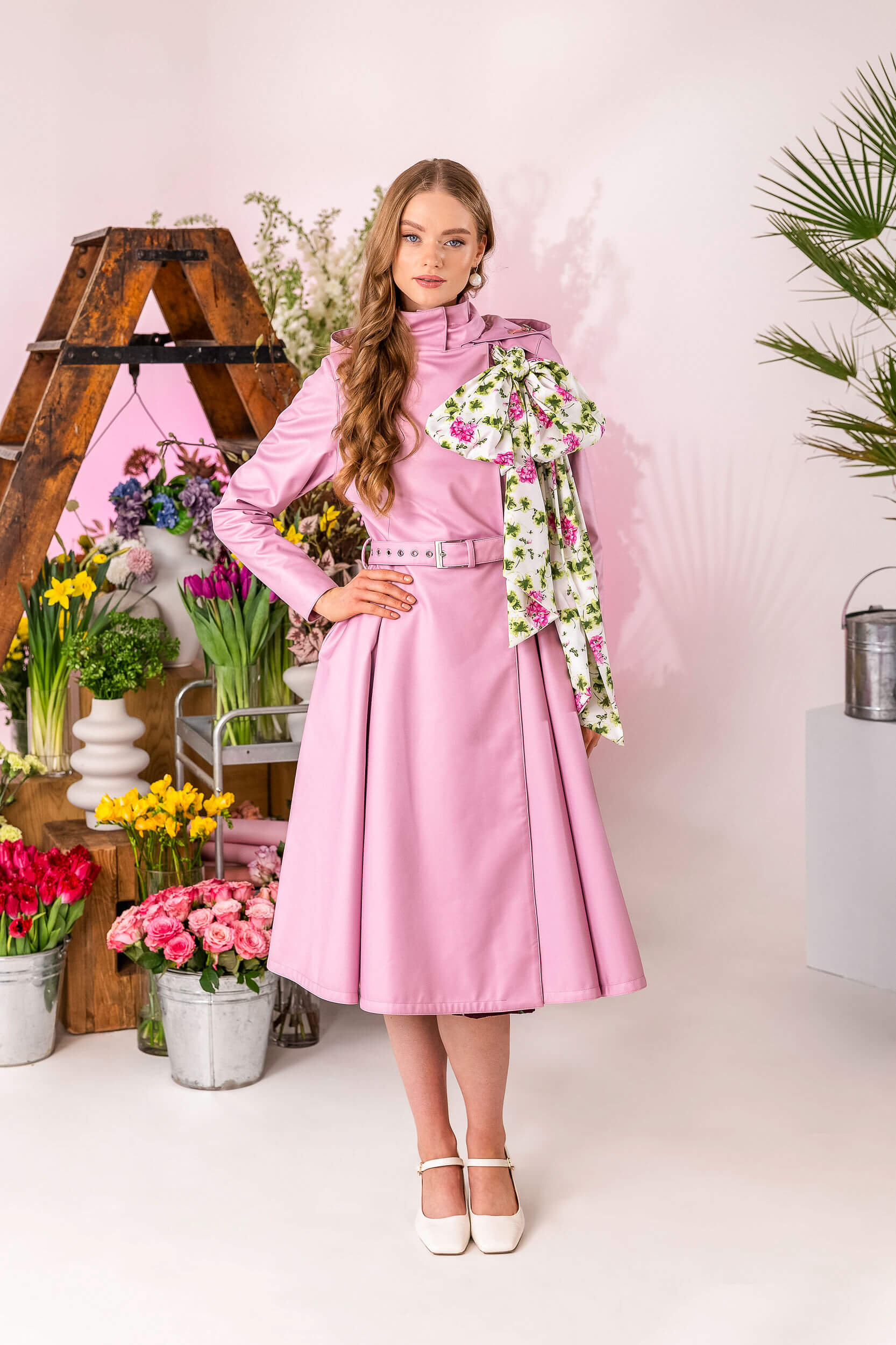 Feminine waterproof coat with flowing shape and delicate scarf accent