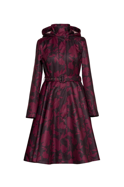 A long-sleeved hooded raincoat with a dark burgundy and dark brown floral pattern by RainSisters, featuring a matching waist belt with a silver buckle, shown on a plain white background.