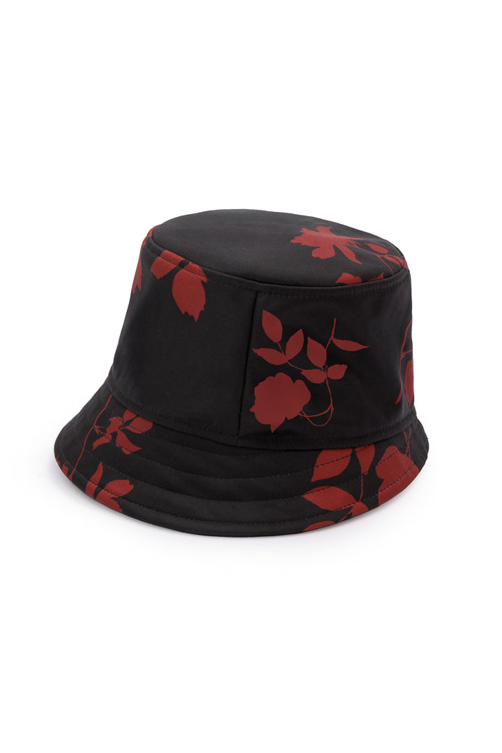 A black bucket hat with a red leaf pattern, photographed on a clean white background.