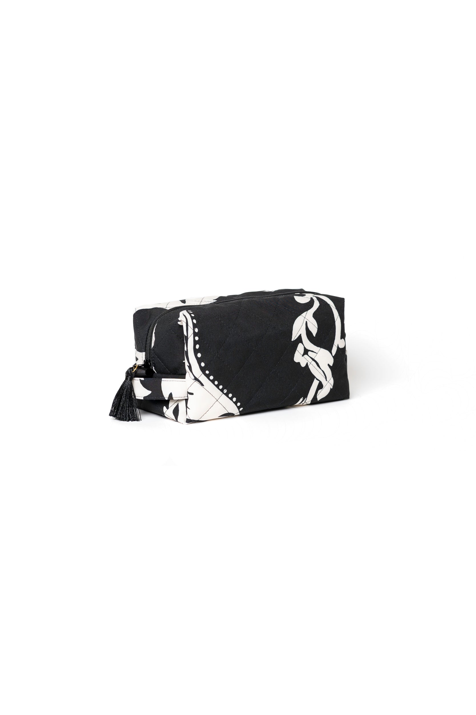 Small black cosmetic bag with white floral print, black zipper, and tassel detail for makeup, skincare, and travel accessories