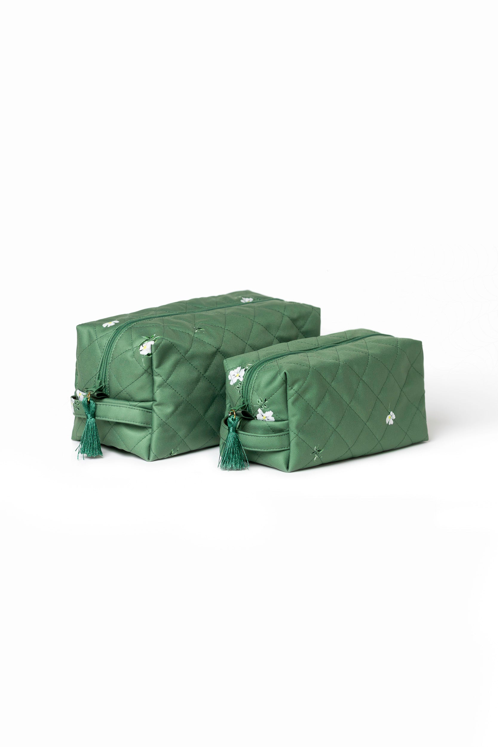 Green floral cosmetic bag set with white floral print, mint lining, green zippers, and decorative tassels.