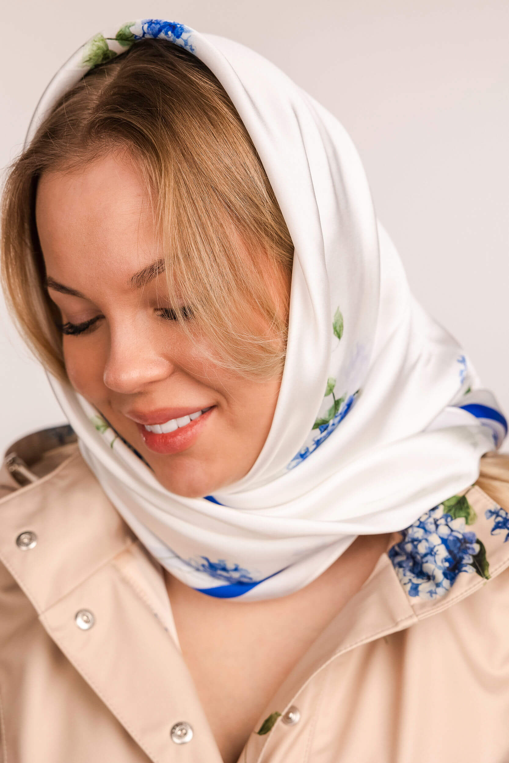 Woman wearing a white headscarf with floral pattern
