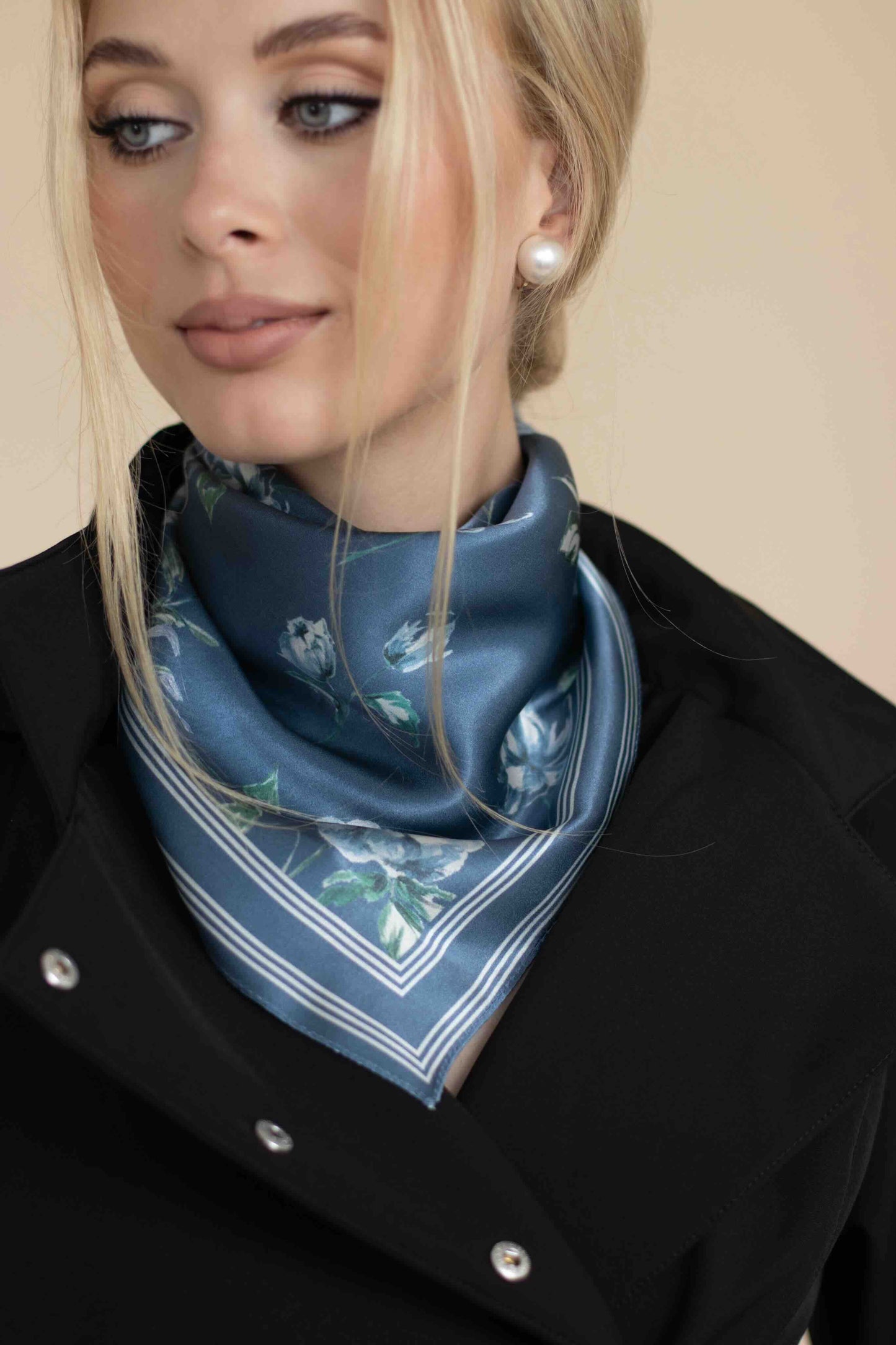 Woman wearing a blue floral scarf on a beige background