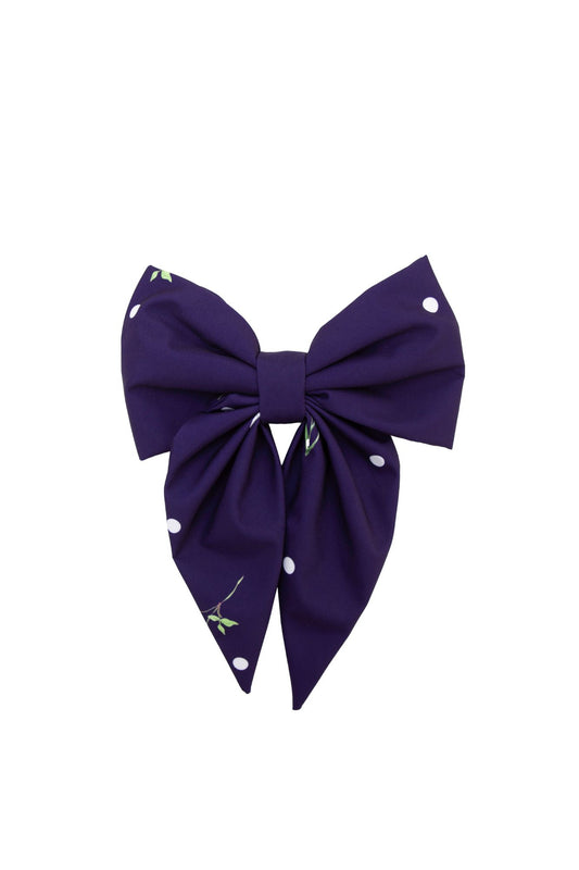 Purple bow with white polka dots on a white background
