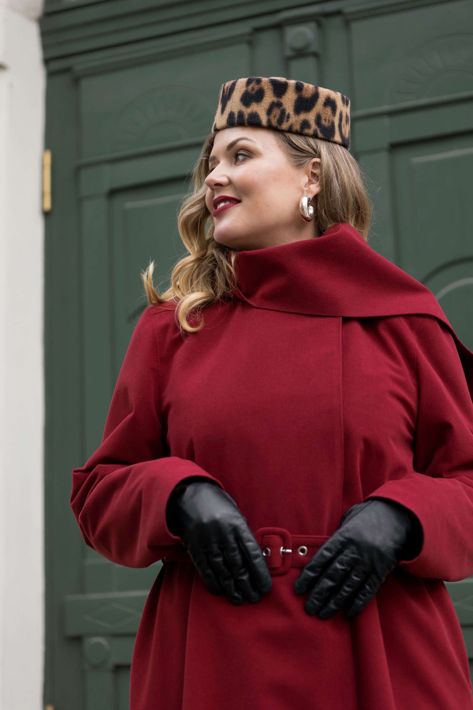 A cozy maroon winter coat with scarf and hood, crafted for elegance and cold weather comfort.