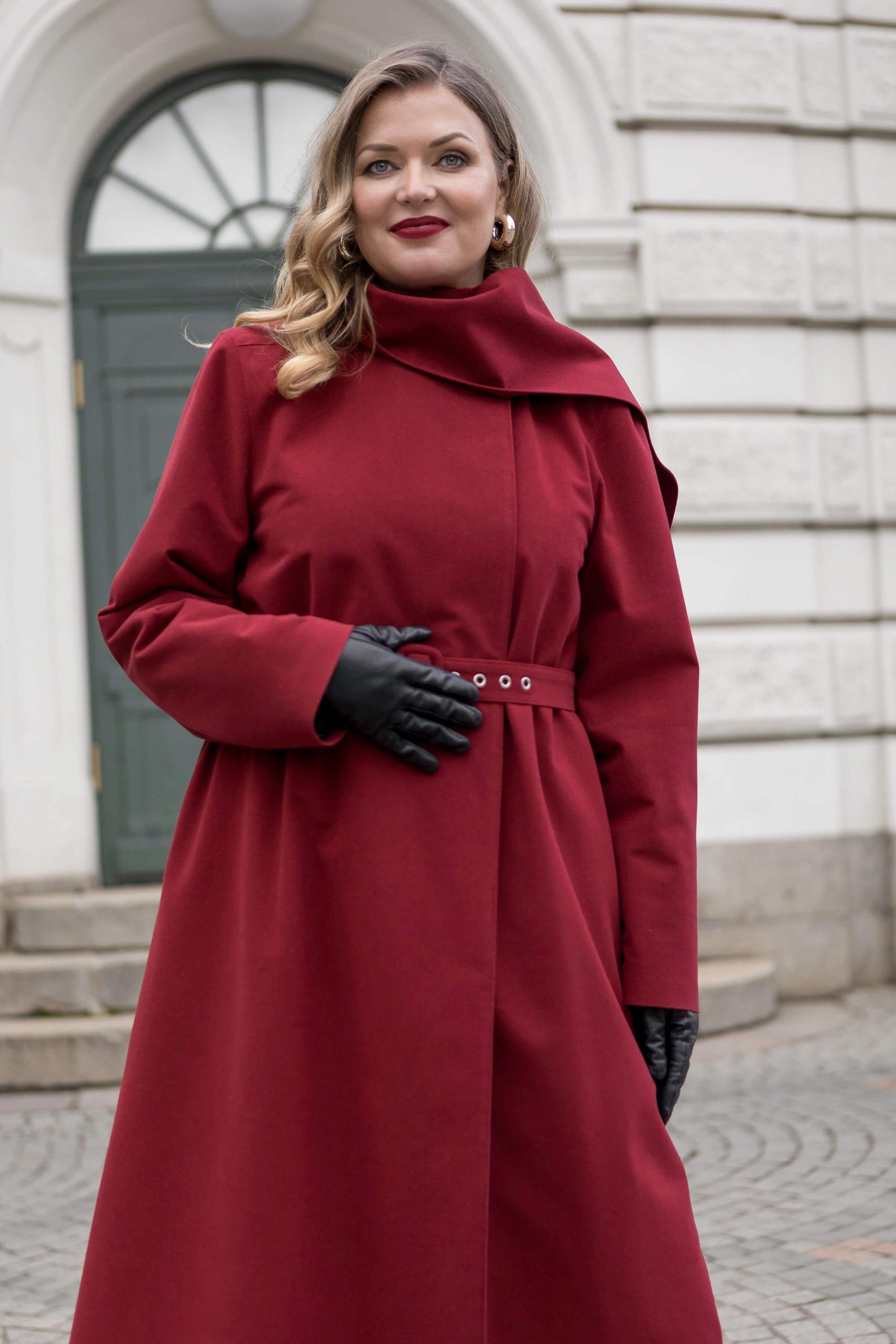 Deep red-brown long coat with matching belt and scarf — an elegant statement for winter city walks.