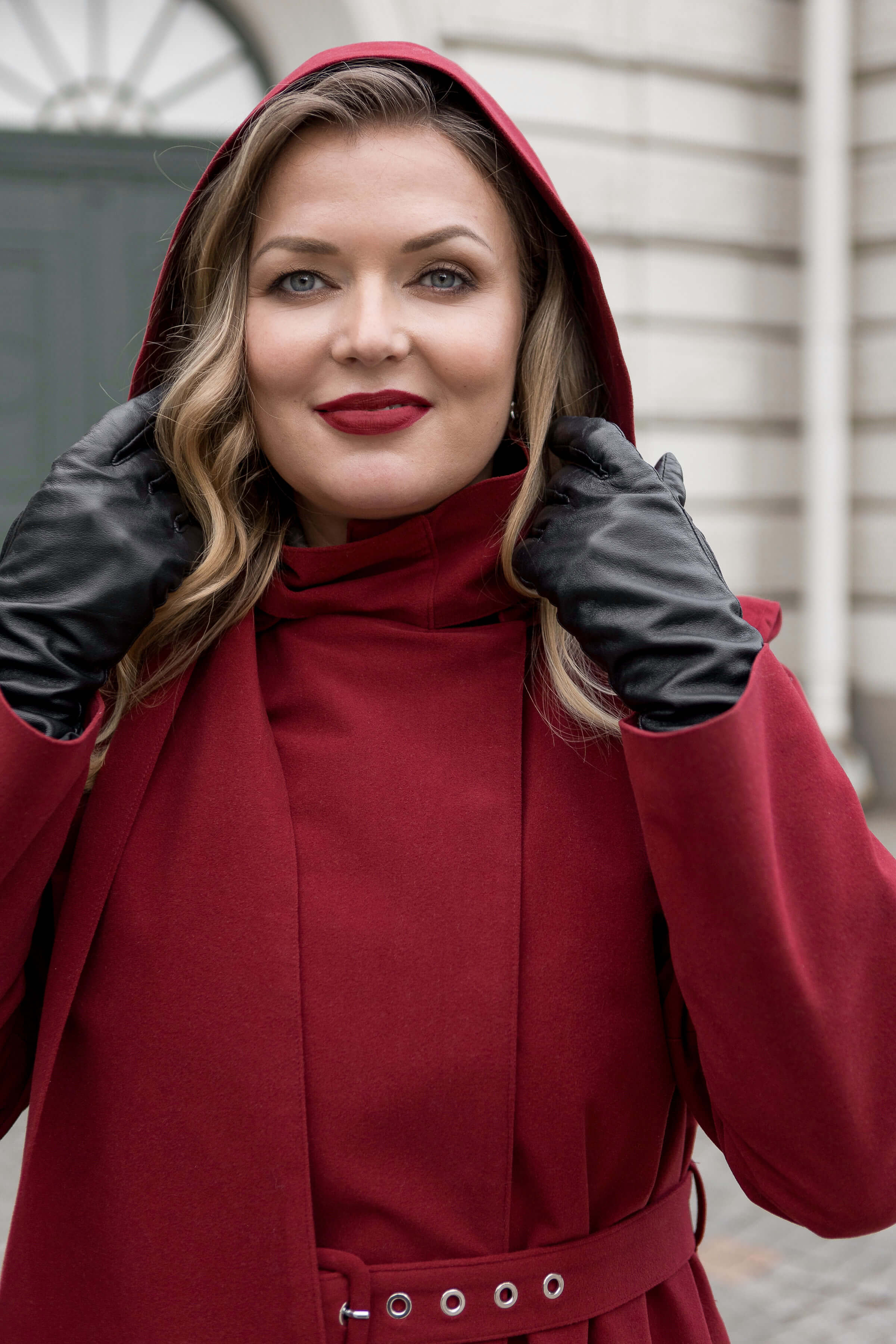The elegant maroon long coat, double-breasted and belted, offers warmth and timeless silhouette.