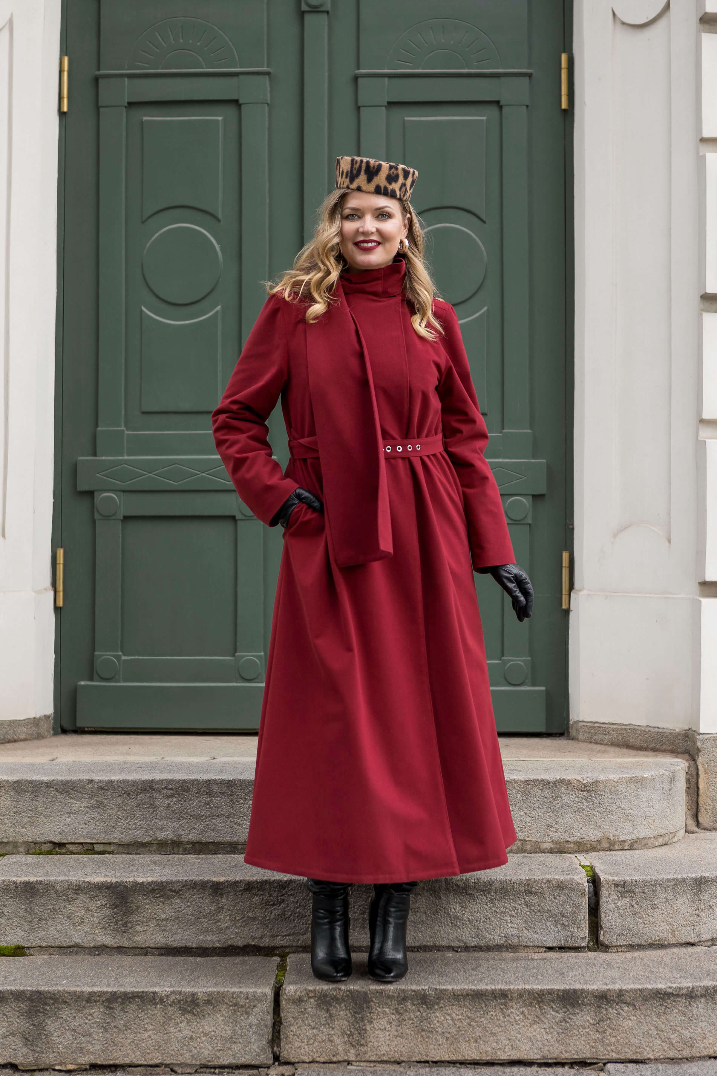 Woman wearing the Winter Maroon long coat by RainSisters — elegant, belted, and warm for cold winter days.