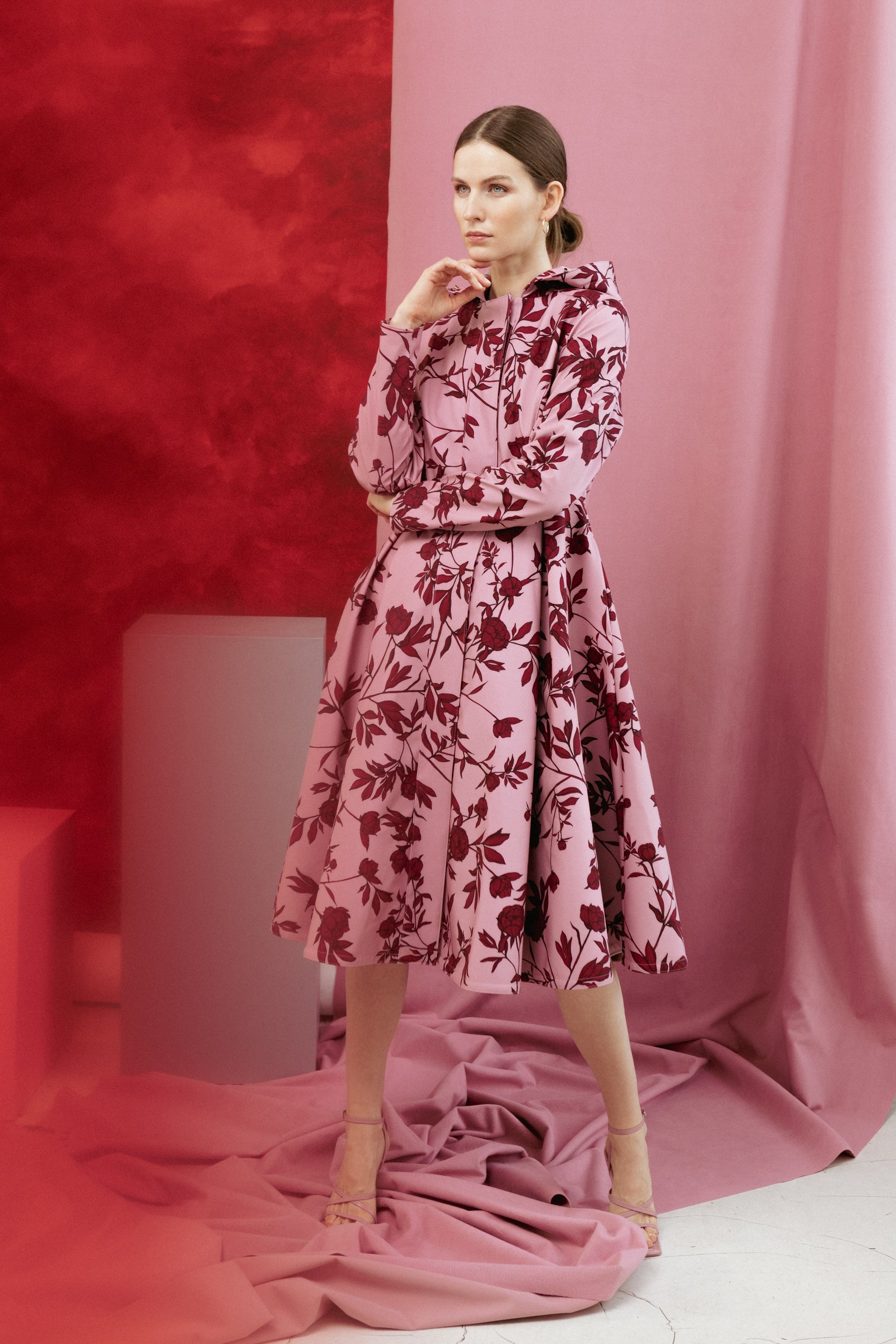 Tall model wearing the Peony Bloom coat, highlighting the flattering fitted bodice and pleated skirt.