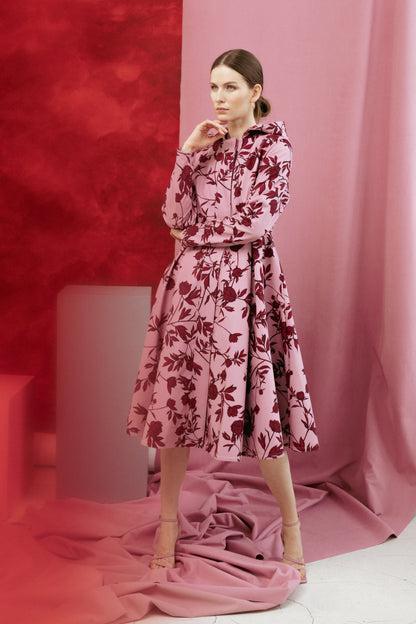 Tall model wearing the Peony Bloom coat, highlighting the flattering fitted bodice and pleated skirt.